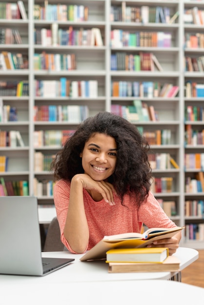 Бесплатное фото Высокий угол девушка учится в библиотеке
