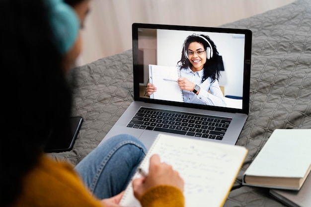 Foto gratuita elevato angolo di adolescente utilizzando laptop per la scuola in linea