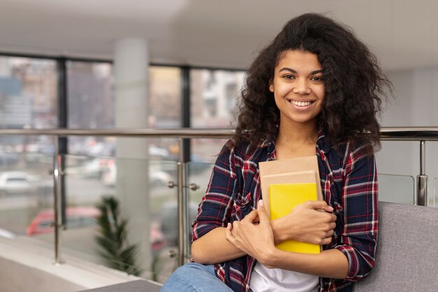 High angle teenage girl with stack of books