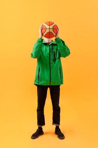 High angle teenager playing with basketball ball