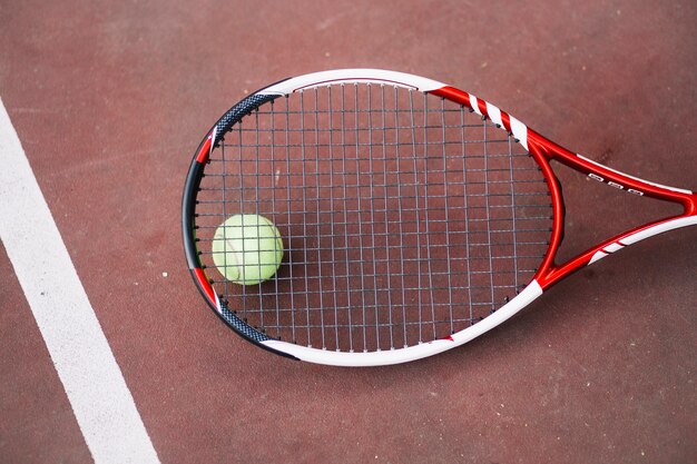 Высокий угол теннисный мяч с ракеткой рядом