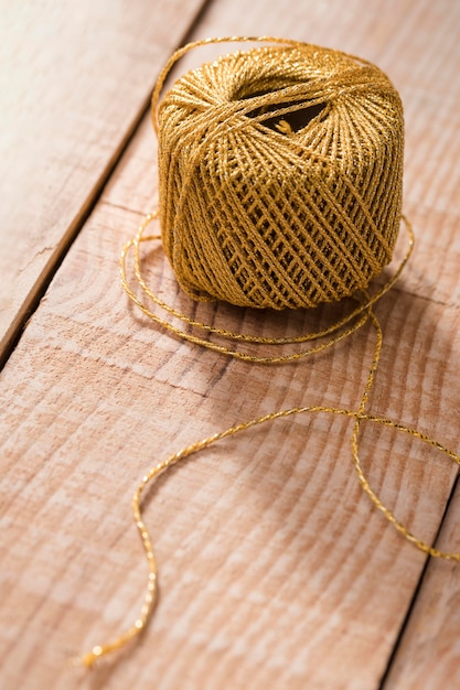 Free photo high angle of thread on wooden surface