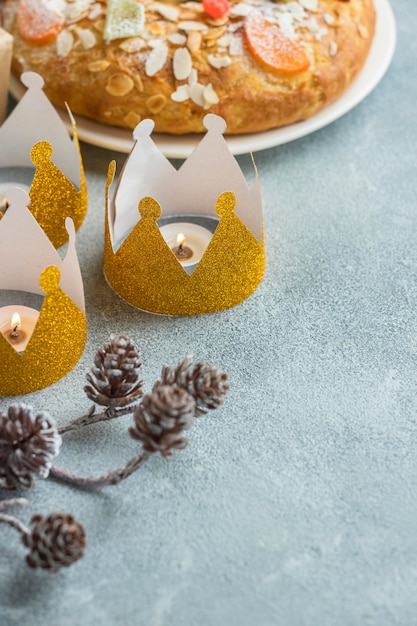 Free photo high angle of three crowns for epiphany day with dessert