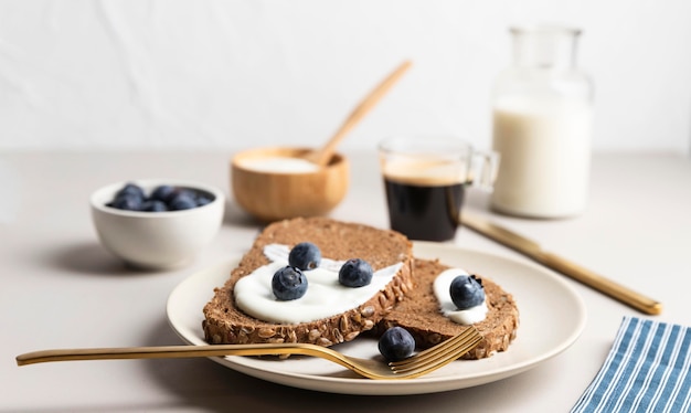 Free photo high angle of toast on plate with blueberries and milk