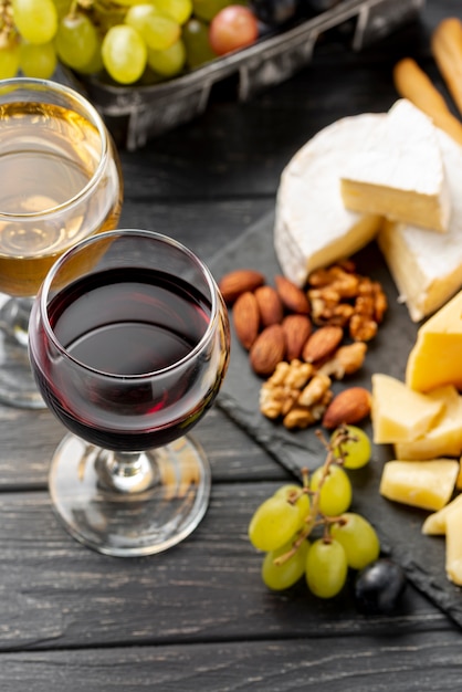 Высокий угол подноса с сыром и красным вином