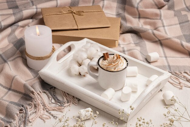 High angle of tray with coffee with whipped cream and candle