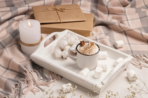 High angle of tray with coffee with whipped cream and candle