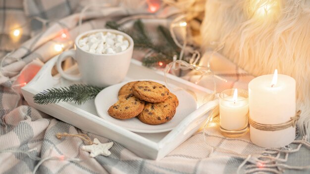 High angle of tray with cookies and mug with marshmallows