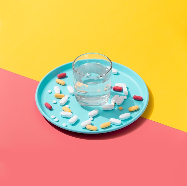 Free photo high angle of tray with pills and glass of water