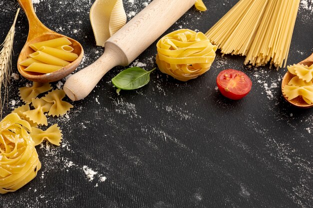 High angle uncooked pasta with rolling pin and copy space