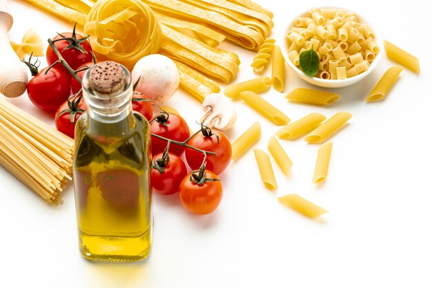 Сырые макароны под большим углом с помидорами и оливковым маслом