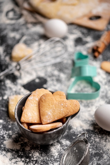 High angle of valentines day cookies with whisk and eggs