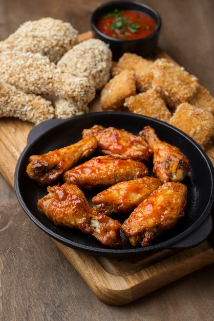 High angle of variety of fried chicken with sauce