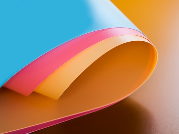 Высокий угол ярких красочных гнутых листов бумаги