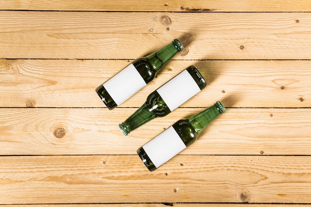 Free photo high angle view of alcoholic bottles on wooden surface