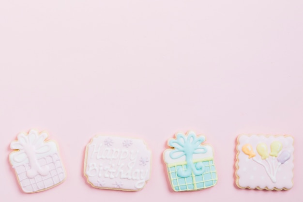 High angle view of birthday cookies on pink background