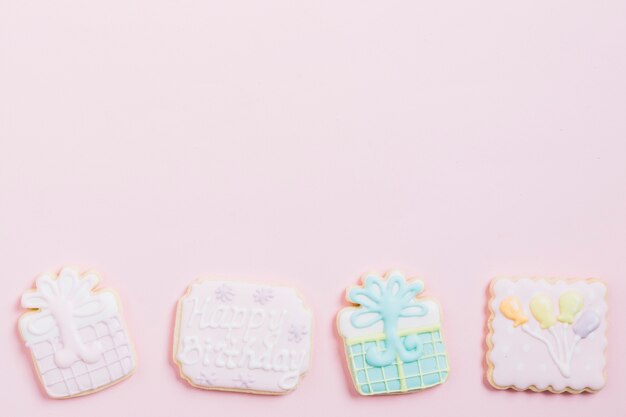 High angle view of birthday cookies on pink background