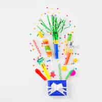 Free photo high angle view of birthday gift candies and party accessories on white surface