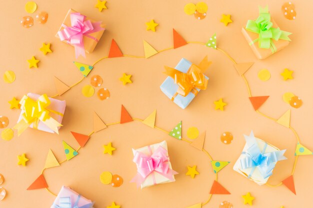 High angle view of birthday gifts and party accessories on colored background