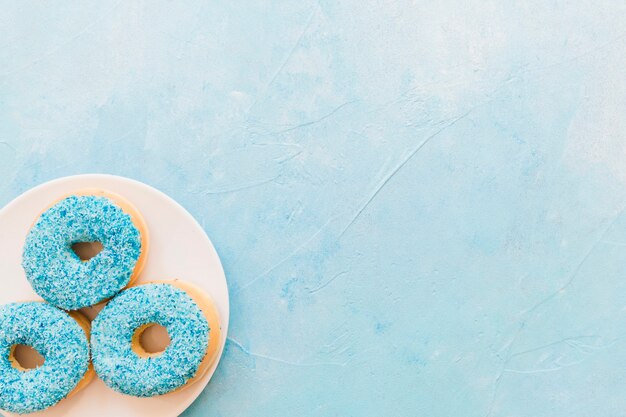 Free photo high angle view of blue donuts on plate