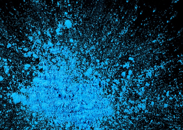 Free photo high angle view of blue holi powder on black background