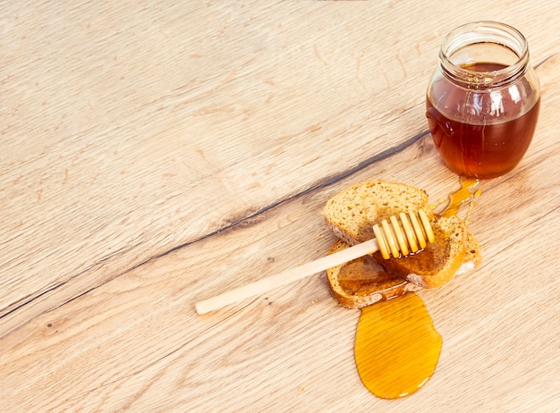 Free photo high angle view of bread and honey with honey dipper