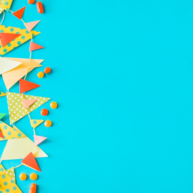 High angle view of candies and bunting on blue background