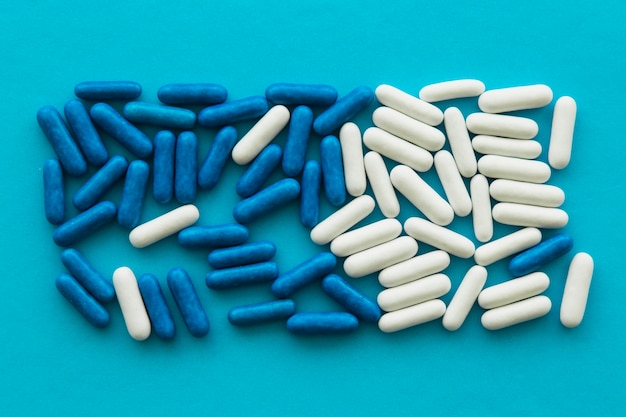 High angle view of candy capsules on blue background