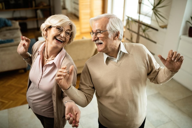 High angle view of carefree senior couple having fun while dancing at home