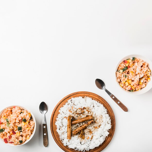High angle view of chinese fried and steam rice with cinnamon sticks on white backdrop