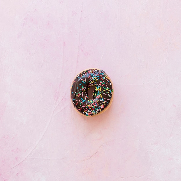 Free photo high angle view of chocolate donut on pink background