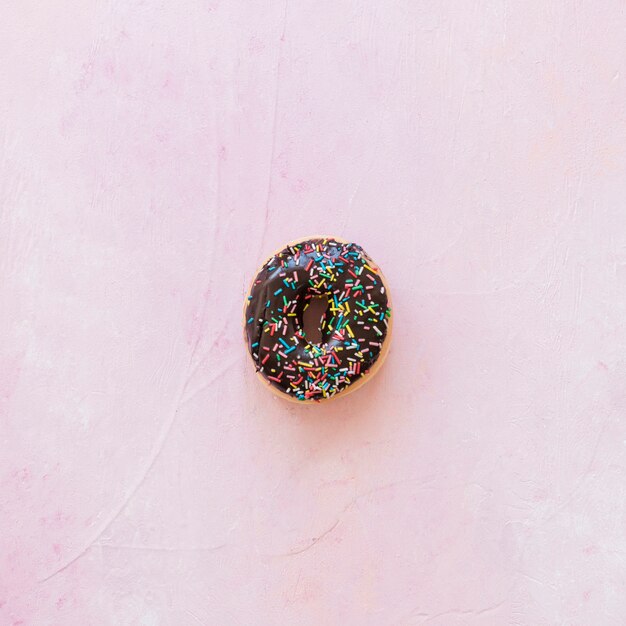 High angle view of chocolate donut on pink background