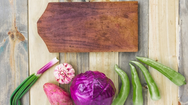 High angle view of chopping board with fresh healthy vegetables on wooden surface