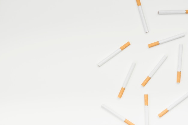 Free photo high angle view of cigarettes against white surface