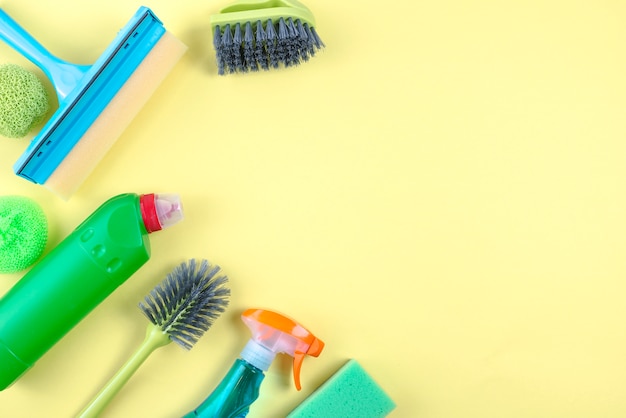 High angle view of cleaning equipments on yellow backdrop