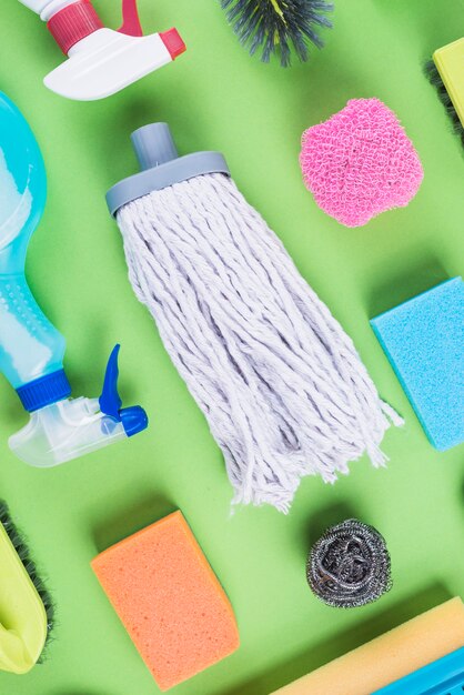 High angle view of cleaning items on green backdrop