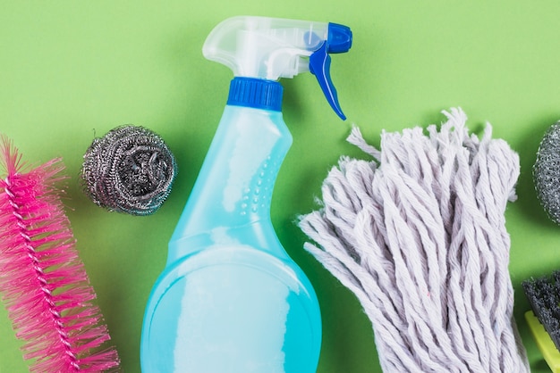 High angle view of cleaning products on green backdrop