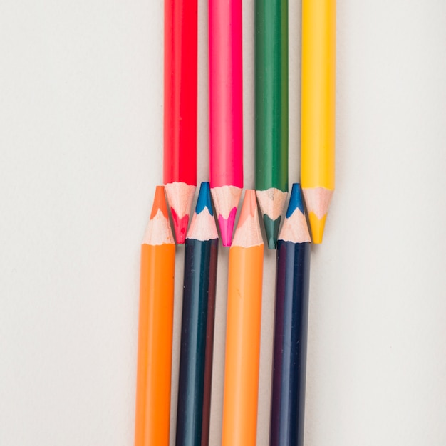 High angle view of color pencils on white backdrop