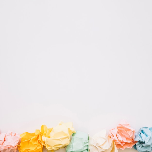 High angle view of colorful crumpled papers on white background