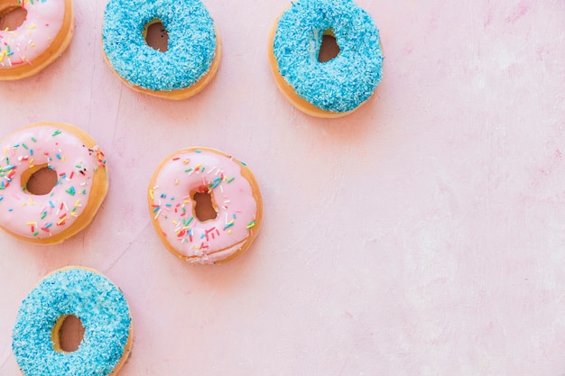 High angle view of colorful donuts on pink background