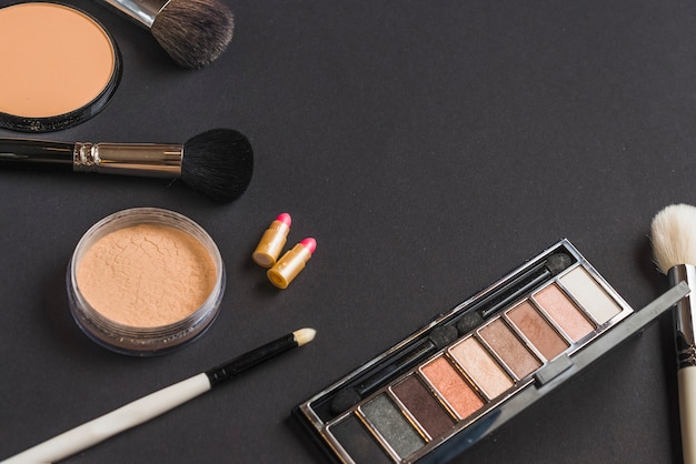 High angle view of cosmetic products on black backdrop