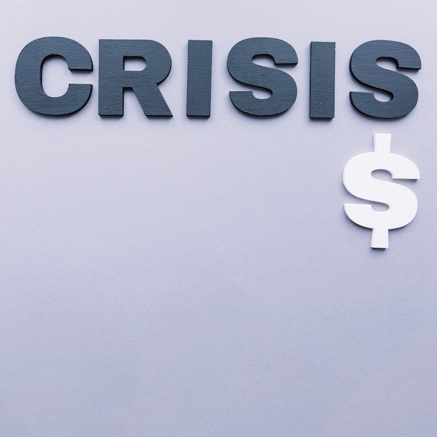 High angle view of crisis word with dollar sign on grey backdrop