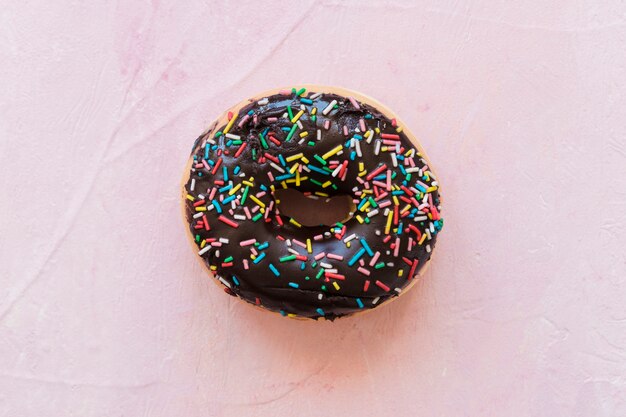 High angle view of delicious chocolate donut on pink backdrop