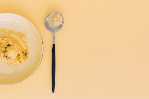 High angle view of delicious hummus on colored background