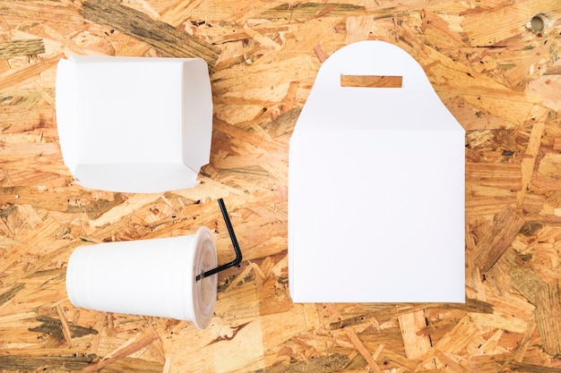木製テーブルトップ上の処分用カップと小包の高い角度のビュー