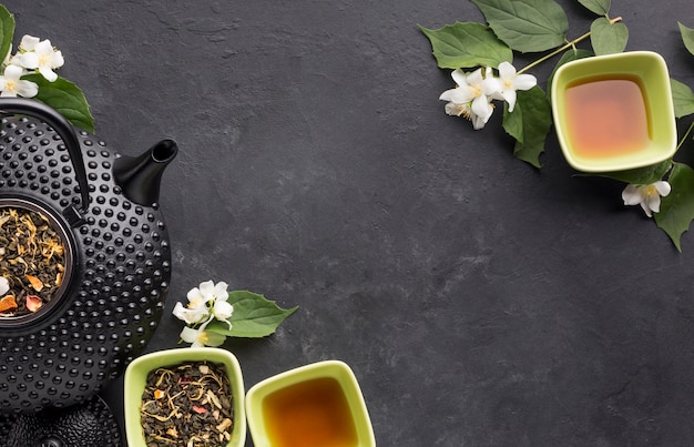 High angle view of dry leaves and herb tea on textured backdrop