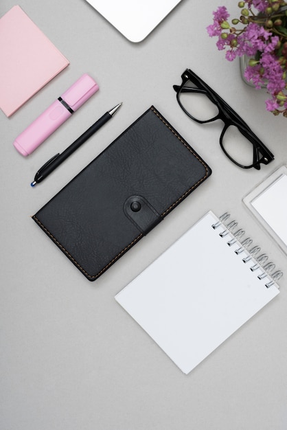 High angle view of eyeglasses with stationery over gray background