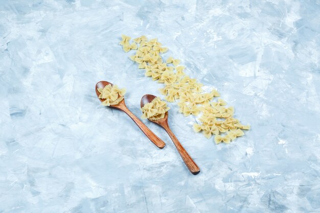 汚れた灰色の背景に木のスプーンで高角度ビューファルファッレパスタ。水平