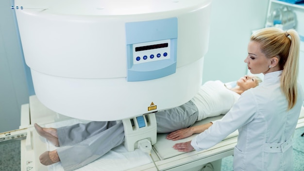 클리닉에서 무릎 MRI 스캔 중 여성 방사선 전문의와 환자의 높은 각도 보기