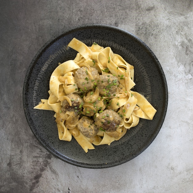 High angle view of fettuccine with meatballs and sauce in a bowl under the lights